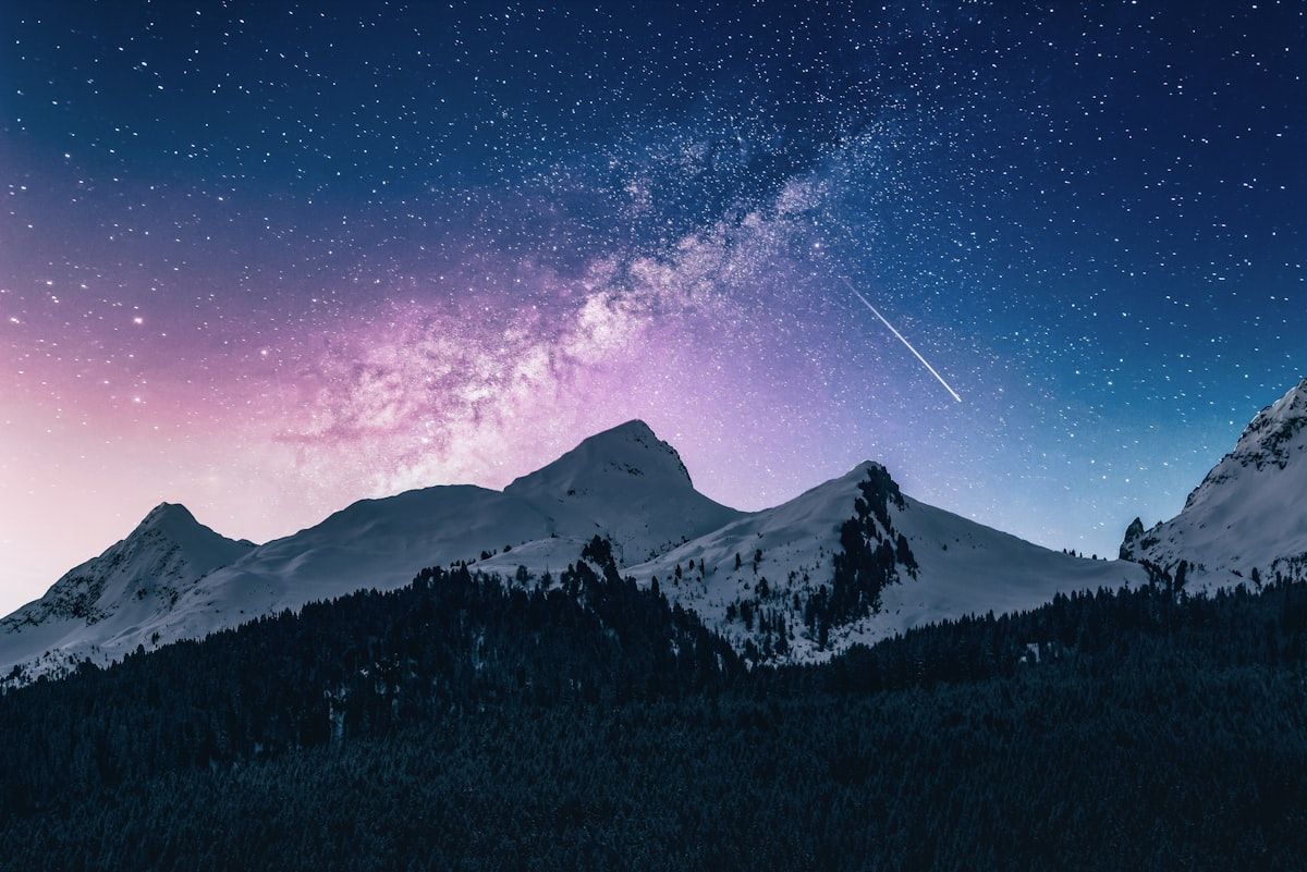 Snow-covered Atlas mountain summit under a starry night sky